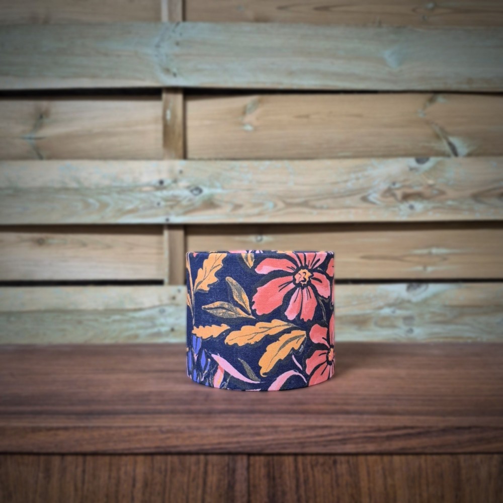 abat-jour cylindrique tissu fleuri aux motifs corail, rose et moutarde sur un fond violet profond