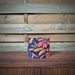 abat-jour cylindrique tissu fleuri aux motifs corail, rose et moutarde sur un fond violet profond